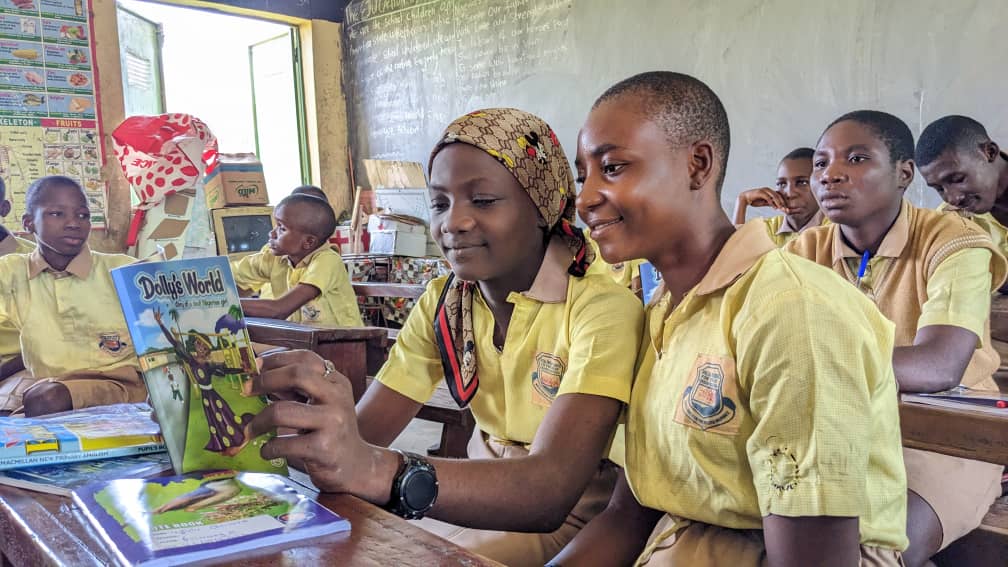 Author reading to a diverse group of children at a book launch event